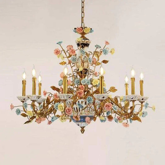 Close-up of the gold chandelier's central body, showcasing intricate ceramic rose and leaf detailing with a vase-like element.