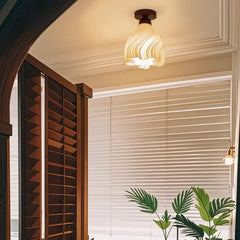 Ceiling light fixture in a room with a bookshelf and plants