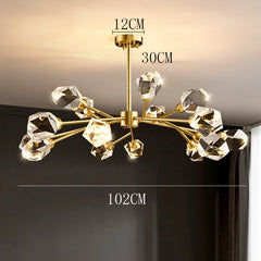 Gold chandelier with crystal-like arms on a dark background, showing measurements.