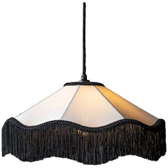 Close-up of a fabric fringe pendant light with a white shade and black fringe, illuminated from within.