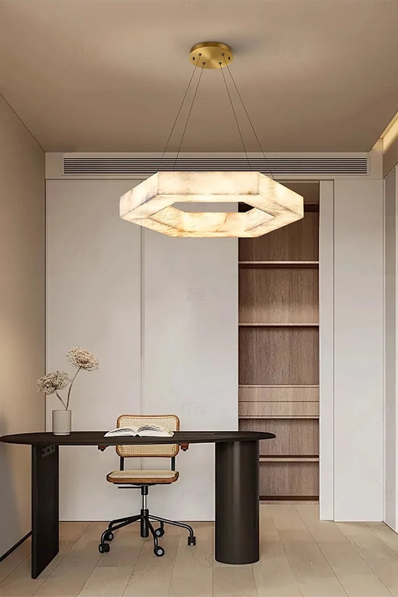 Modern office space with a hexagonal chandelier, desk, and chair.