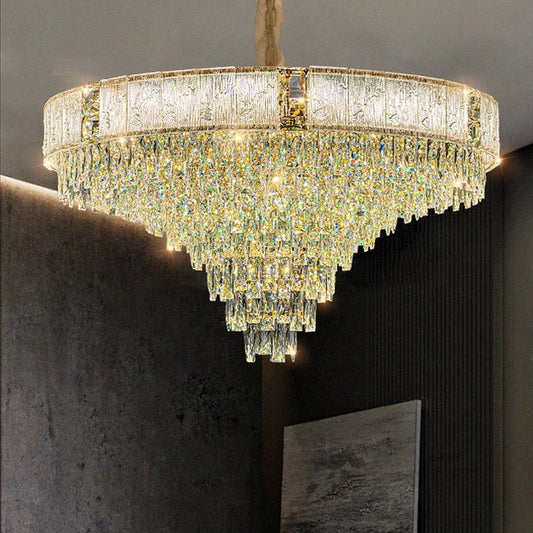 A luxurious gold chandelier with multiple tiers of cascading clear crystals against a dark background.