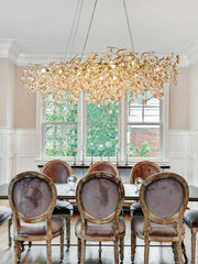 Dining room with a large ornate chandelier, table, and chairs.