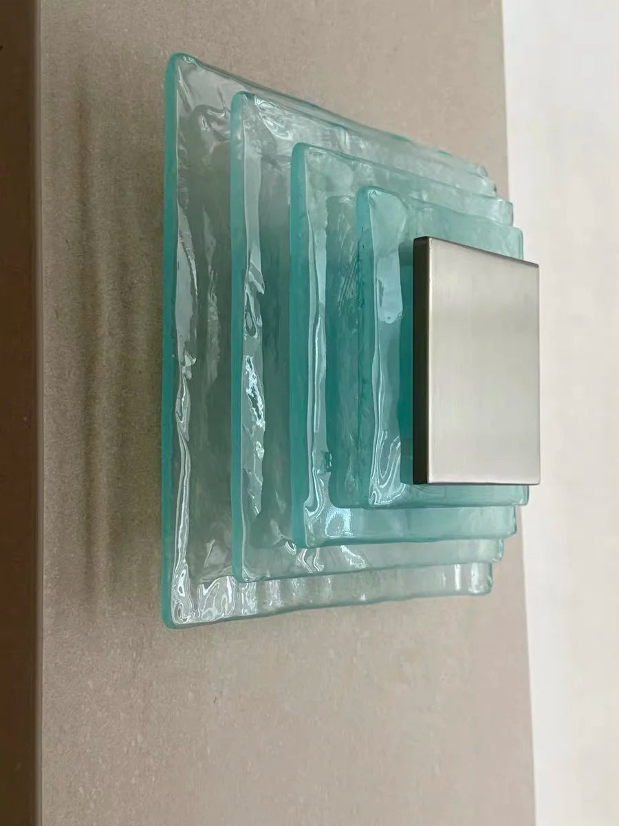 Decorative wall light fixture with glass block design on a neutral background