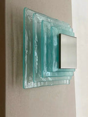 Decorative wall light fixture with glass block design on a neutral background