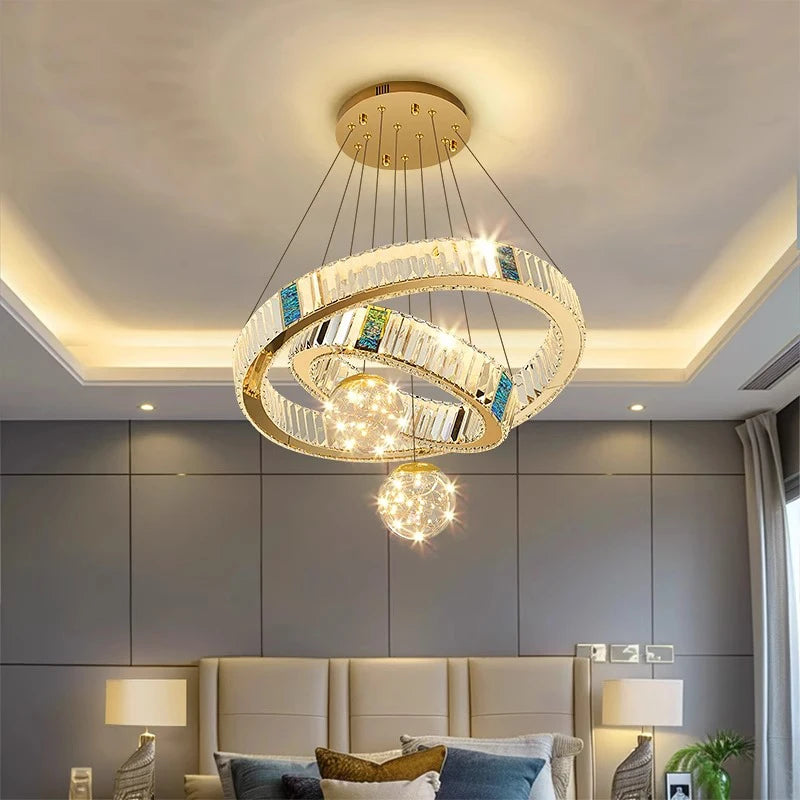 Modern chandelier in a bedroom setting with gray walls and a bed.