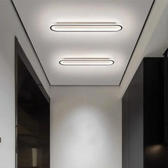 A modern hallway with two oval flush mount ceiling lights on the ceiling.