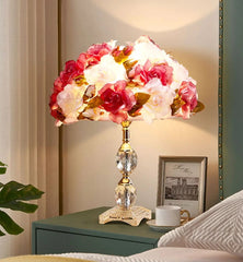 Decorative table lamp with floral design on a nightstand.