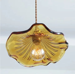 Amber glass pendant light with a clear bulb on a white background