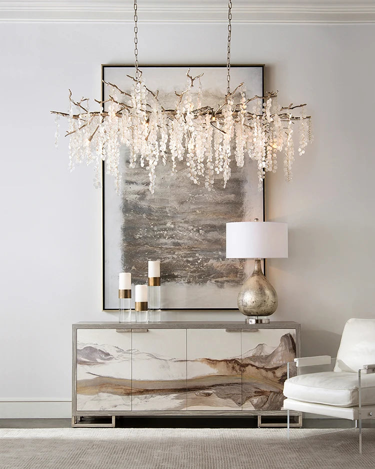 Modern interior design with a chandelier, framed abstract art, and a side table.