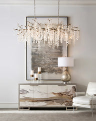 Modern interior design with a chandelier, framed abstract art, and a side table.