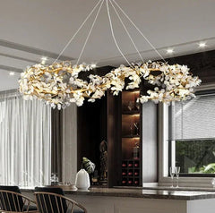 Modern chandelier hanging in a stylish interior setting with a kitchen in the background.