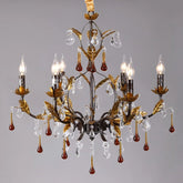 Gold leaf crystal candelabra chandelier with amber droplet accents against a grey background