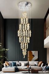Luxurious chandelier hanging above a modern living room with a gray sofa and decorative pillows.