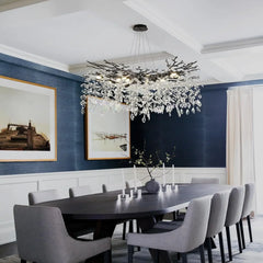 Dining room with a modern chandelier, dark wooden table, and gray chairs.