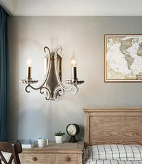 Decorative wall sconces above a wooden nightstand with a world map on the wall.
