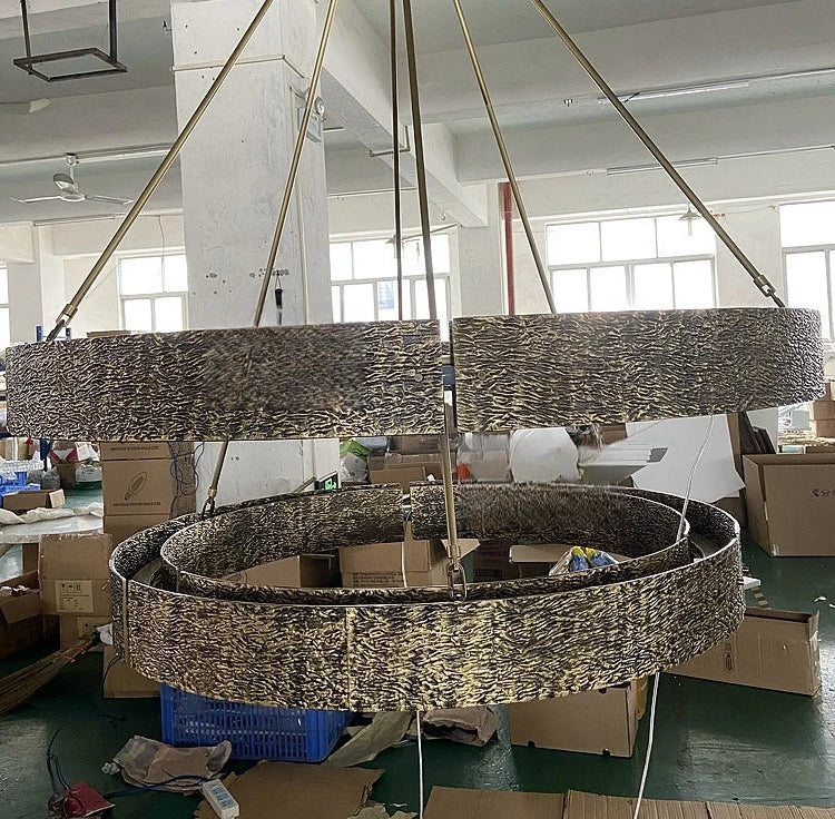 Large decorative chandelier in a warehouse setting with boxes and equipment around.