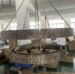 Large decorative chandelier in a warehouse setting with boxes and equipment around.