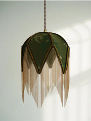 Decorative pendant light with green fabric shade and gold fringe