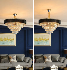 Chandelier hanging above a gray sofa with a blue wall and framed artwork in the background.