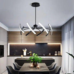 Black chandelier with twisted arms and LED lights above a dining table in a contemporary kitchen.