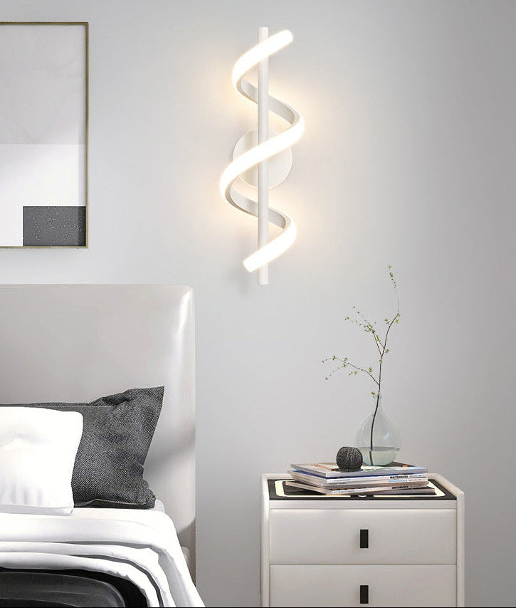 Modern bedroom with a bed, nightstand, and wall-mounted light fixture.