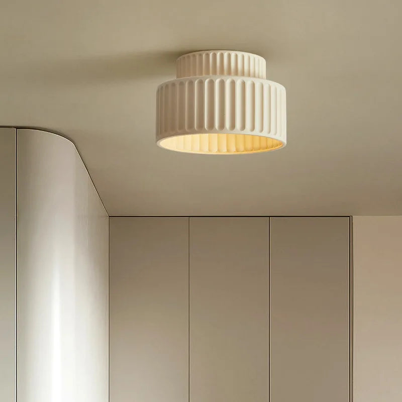 White flush mount resin light with ribbed texture on a neutral ceiling