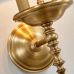 Brass wall sconce with intricate design on a light background