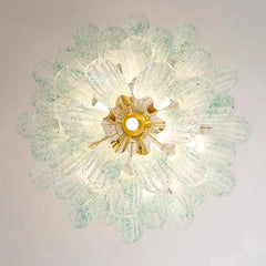 Top-down view of a gold chandelier with numerous light green speckled glass elements arranged in a floral pattern.