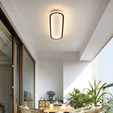 Ceiling light fixture in a modern interior setting with plants and furniture.