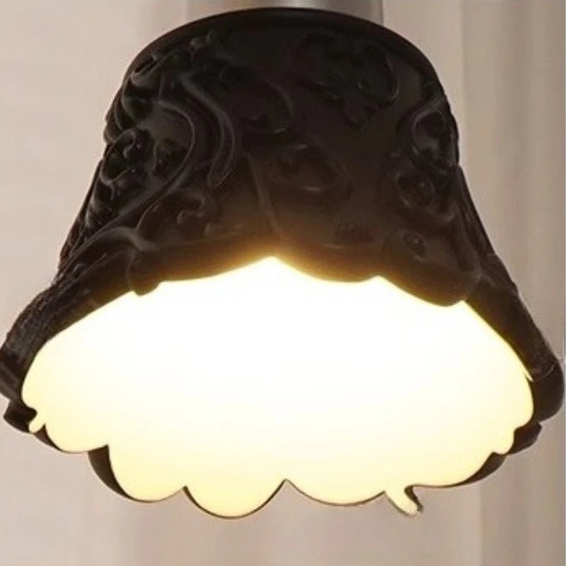 Decorative wall light fixture with scalloped edge on a plain background