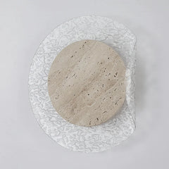 Round stone-like object on a textured glass plate against a light gray background