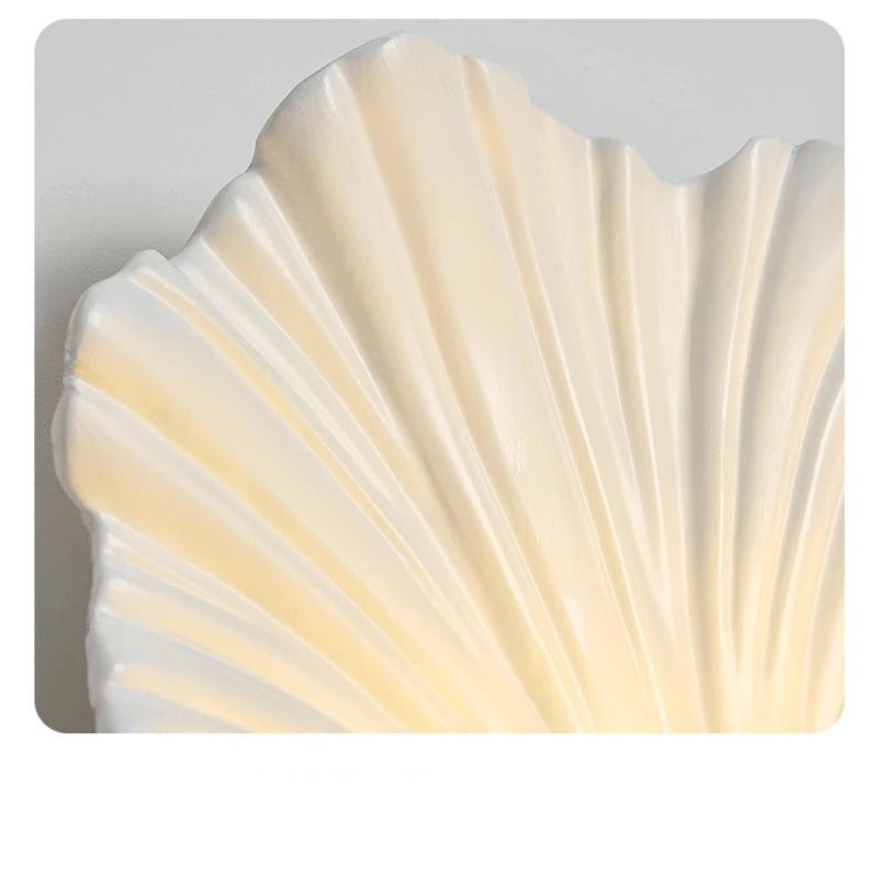 Shell-shaped decorative light fixture with a textured surface on a gray background
