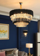 Luxurious chandelier hanging in a room with blue walls and a gray sofa.