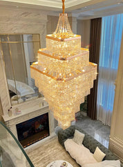 Luxurious chandelier hanging in a living room with a fireplace and sofa.