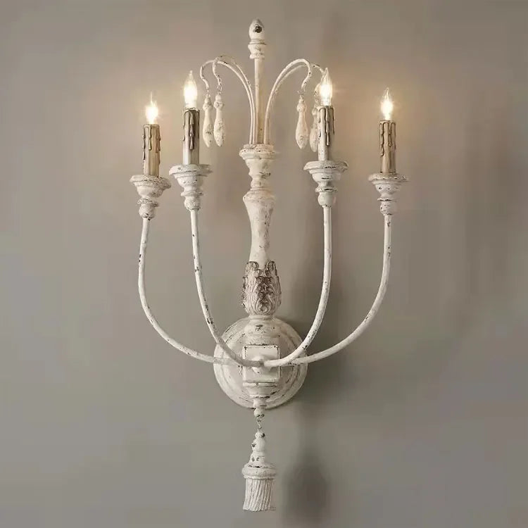 Decorative wall sconce with multiple candle-like lights on a plain background
