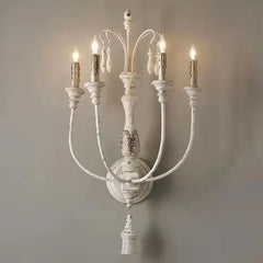 Decorative wall sconce with multiple candle-like lights on a plain background