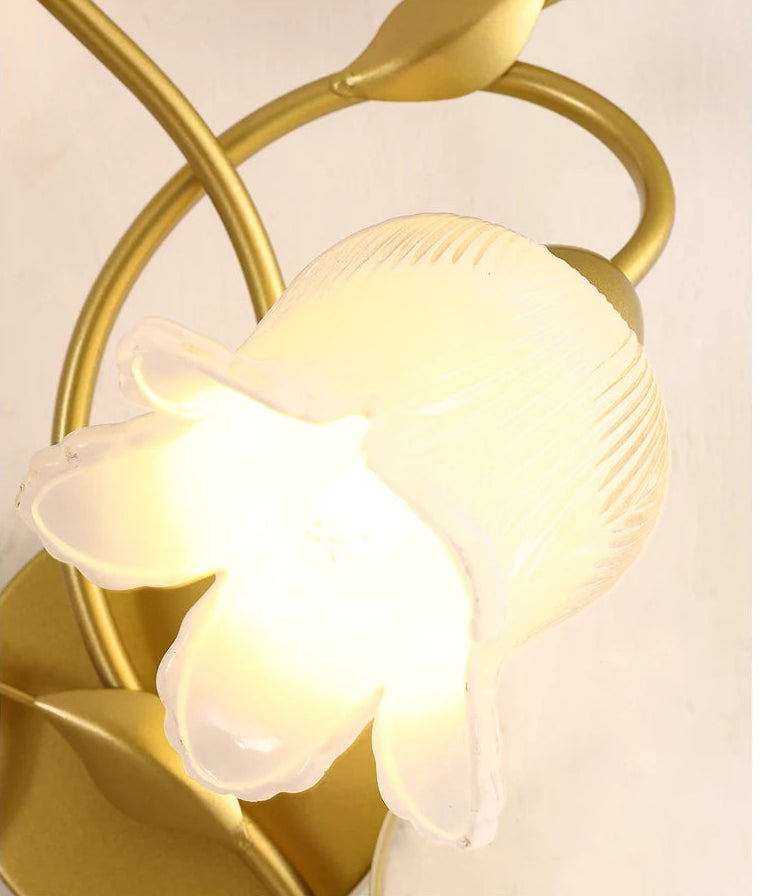 Decorative ceiling light fixture with gold frame and white glass shade on a light background