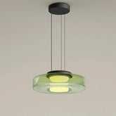 Green glass disk pendant light with a black ceiling mount and cord.