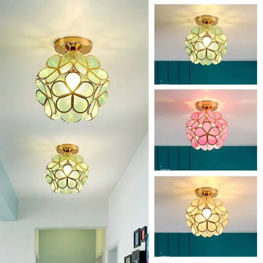 Close-up of a gold flush mount ceiling light with acrylic petals glowing warm white, mounted on a white ceiling.