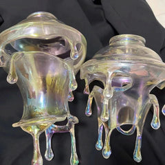 Iridescent glass candle holders on a black background