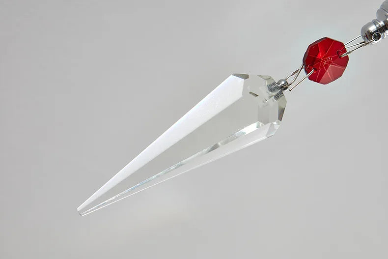 Crystal pendant with a red gem on a gray background