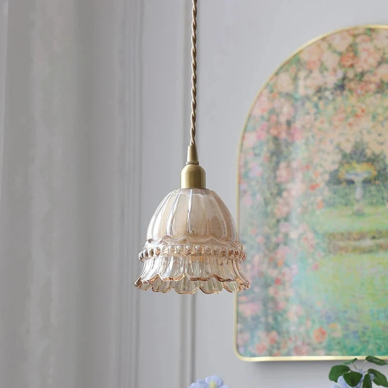 Vintage-style pendant light with floral wall art in the background