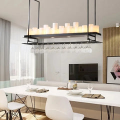 Modern dining room with a chandelier, table, chairs, and a TV in the background.