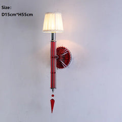 Wall lamp with red decorative element and white shade on a light gray background