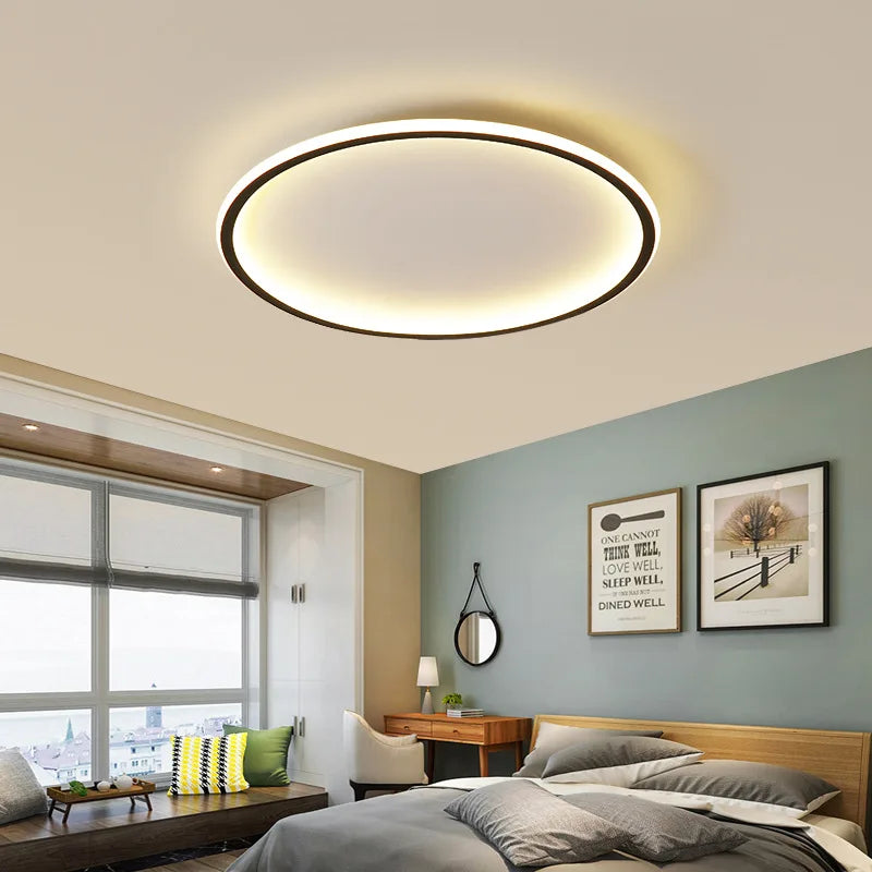Interior view showcasing a modern black circular flush mount ceiling light above a bed.