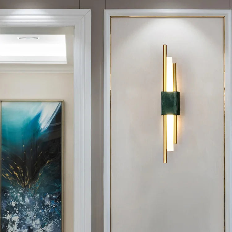 Modern wall sconce on a neutral wall with a painting in the background
