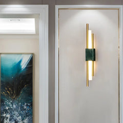 Modern wall sconce on a neutral wall with a painting in the background