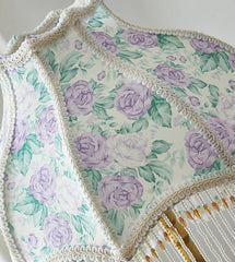 Floral patterned fabric with purple roses on a white background