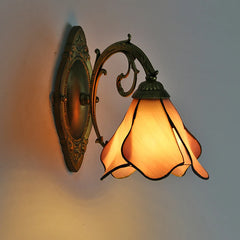 Decorative wall lamp with stained glass shade on a plain background